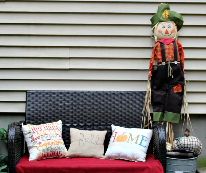 Bench with fall pillows and scarecrow
