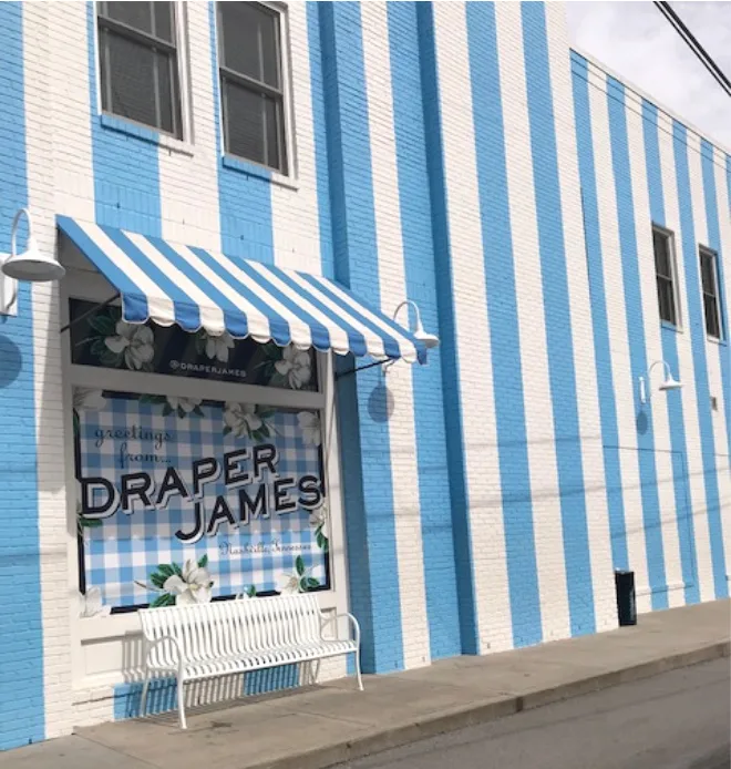 Draper James storefront blue and white striped awning