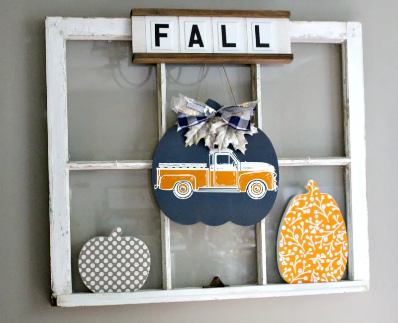 Antique window with diy wood pumpkins shown in fall home decorating post