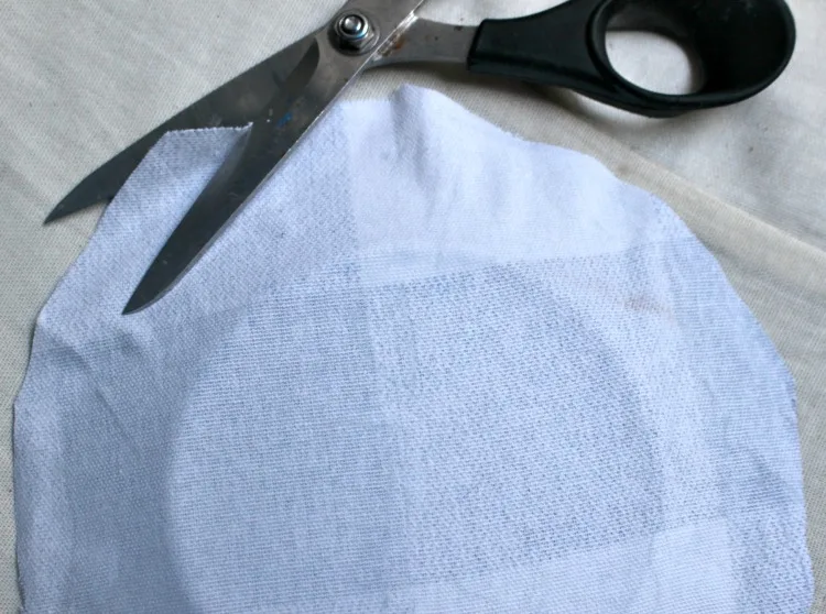 fabric on plate being cut with scissors