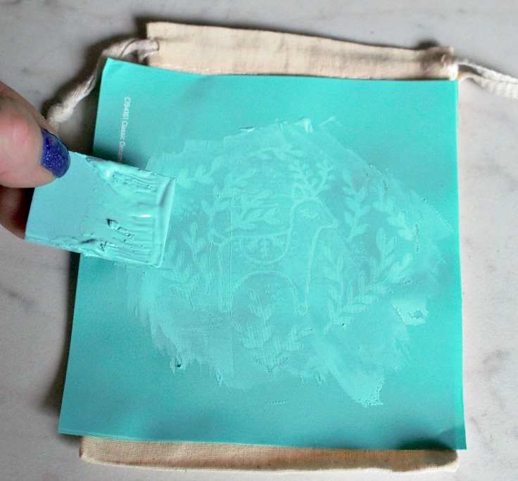 chalk paste being used on canvas bag