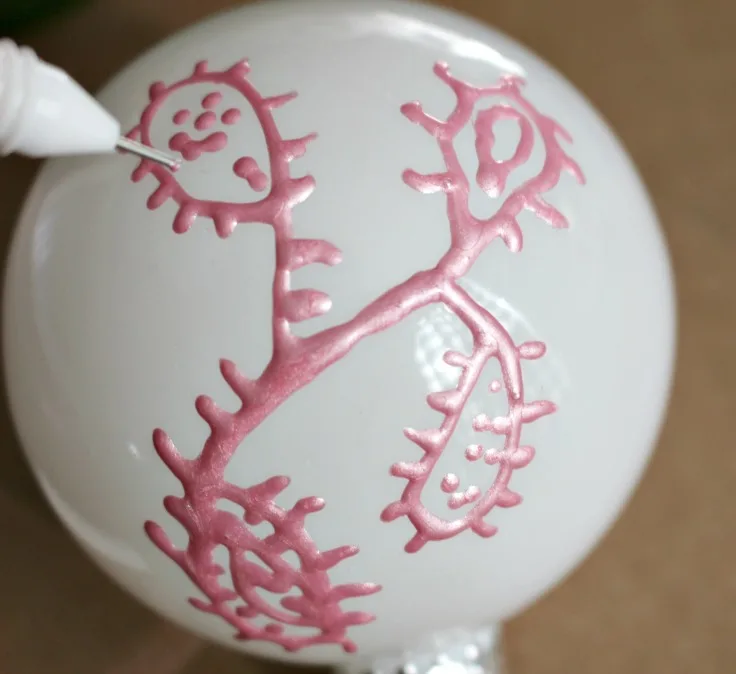 hand painting on white ornaments with pink paint
