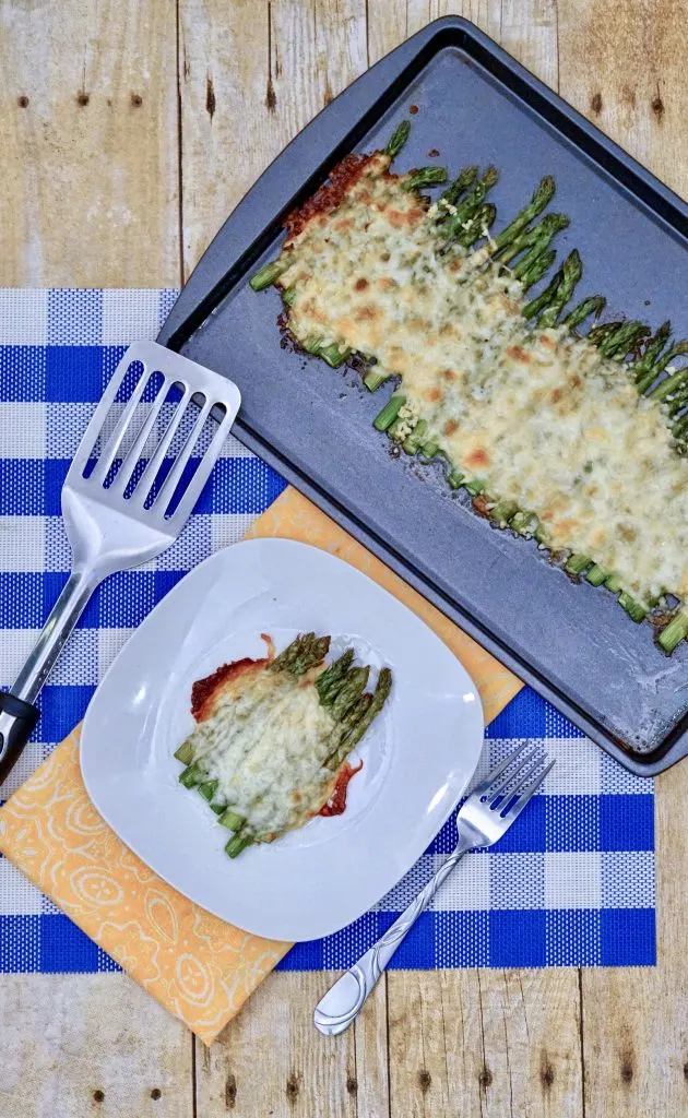 cheesy asparagus on plate and sheet pan