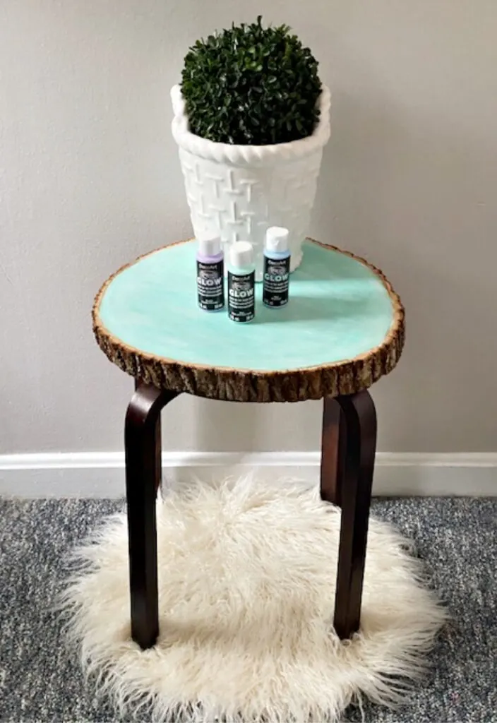 wood slice side table with plant and glow paint