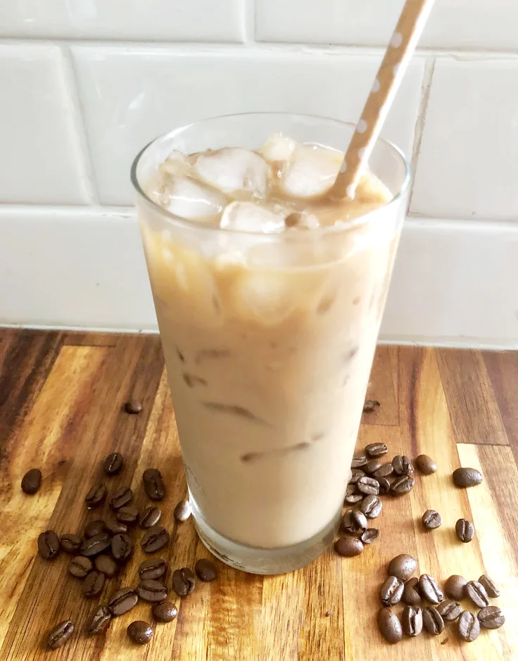 iced coffee on counter with coffee beans