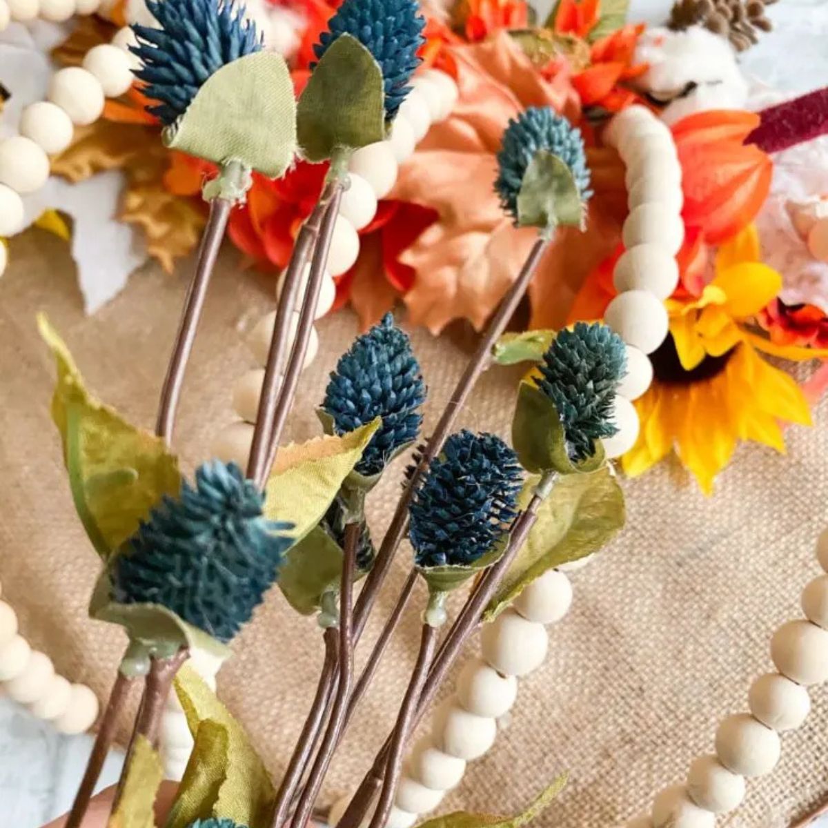 placing fall florals on pumpkin wreath