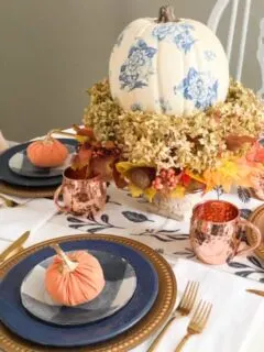 blue and orange fall tablescape with copper mugs