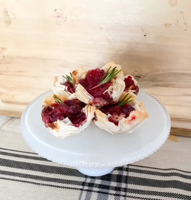 cranberry brie bites on white cake plate