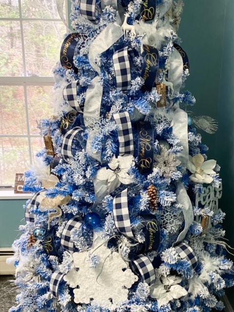 blue flocked Christmas tree with layered ribbon
