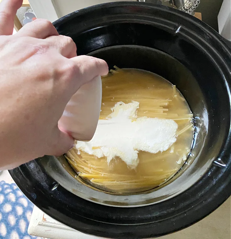 pouring heavy cream in pasta dish