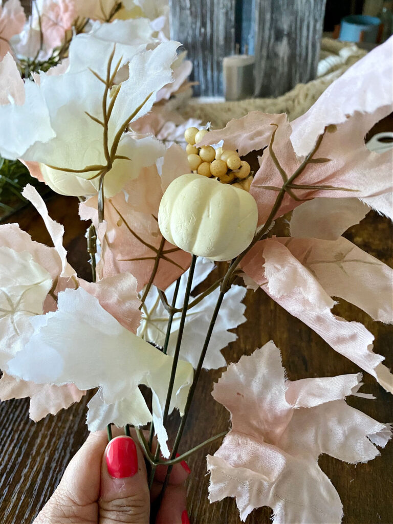 close up of neutral fall leaves and white pumpkins from dollar tree