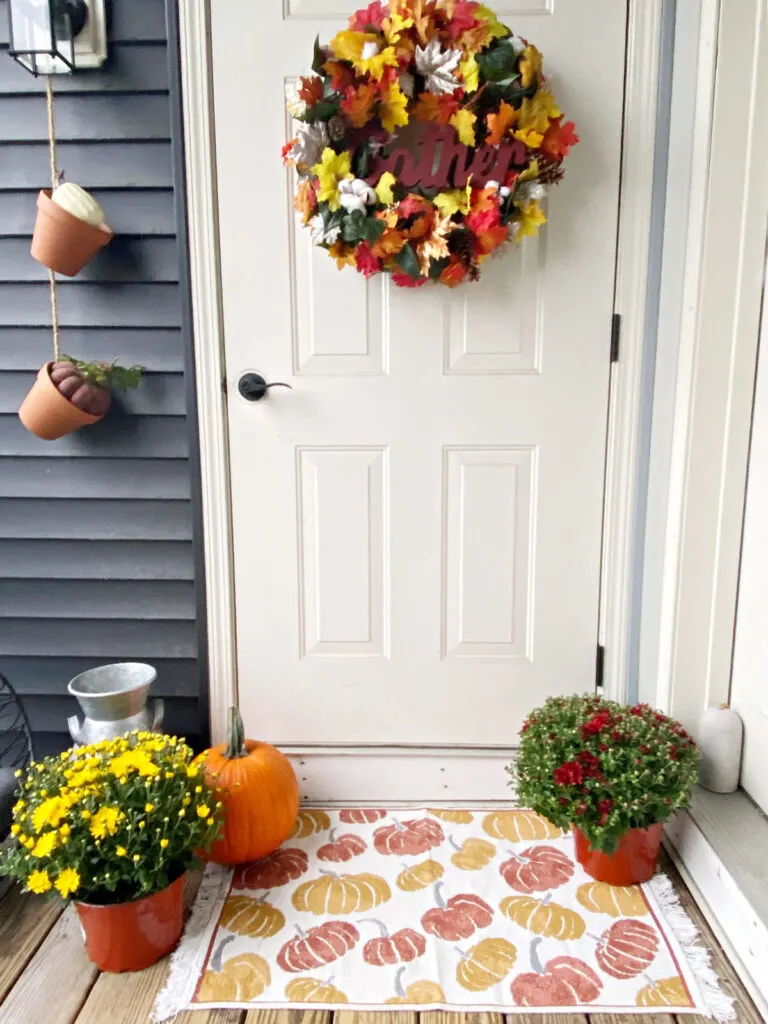 small fall porch with mums and pumpkins