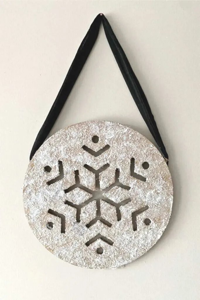 wooden snowflake with velvet ribbon hanging on bedroom wall