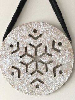 wooden snowflake with glitter hanging on wall