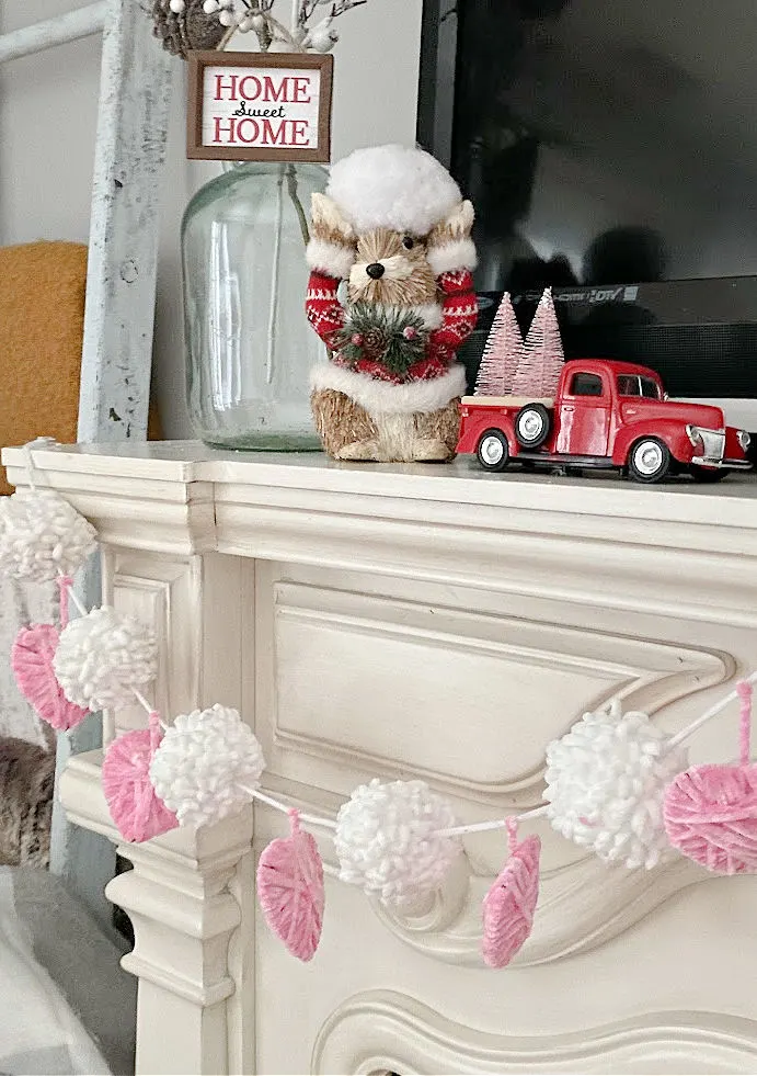 pompom and yarn wrapped hearts banner on mantel
