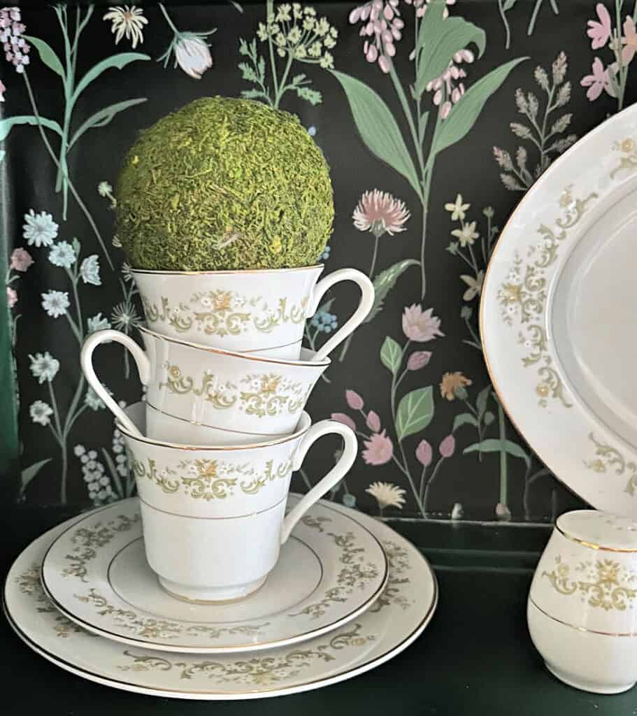 tea cups on hutch with moss ball