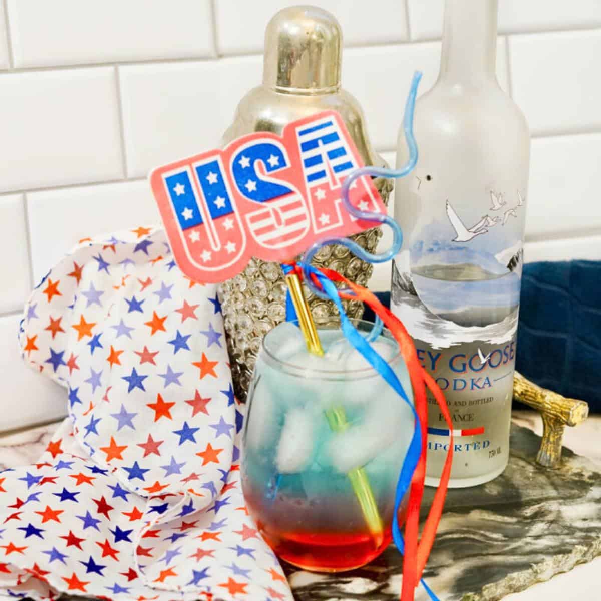 layered red white and blue cocktail on counter with star towel