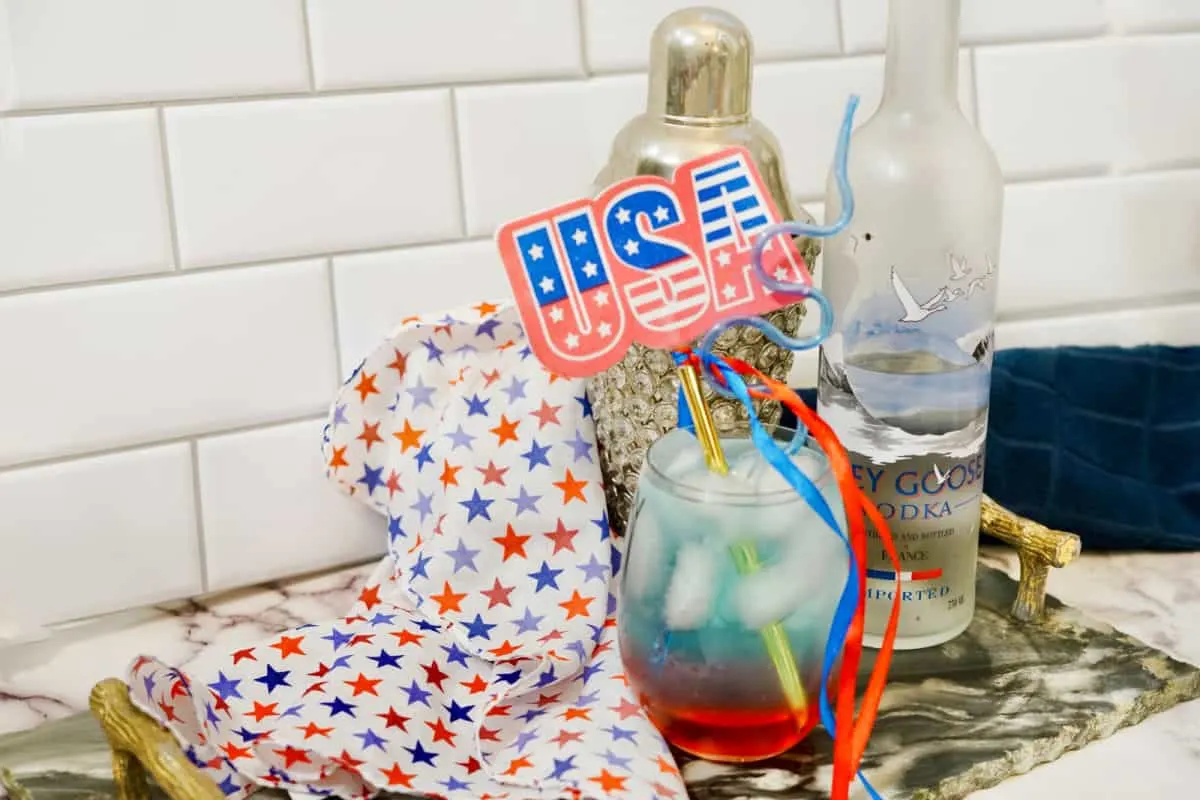 red, white and blue layered cocktail with flag.