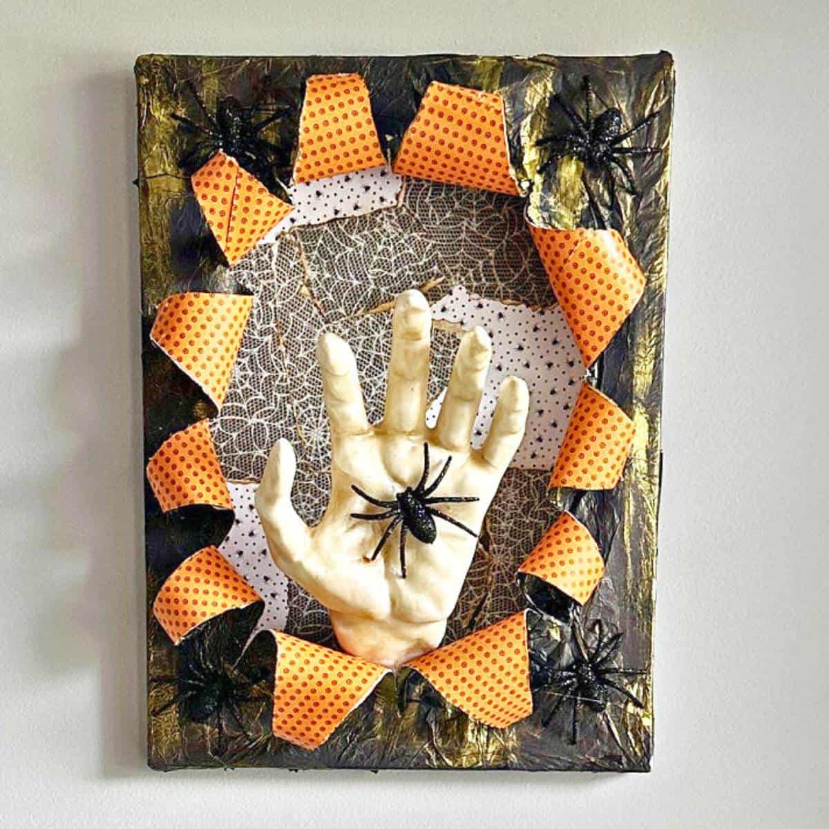 busted canvas halloween art hanging on wall