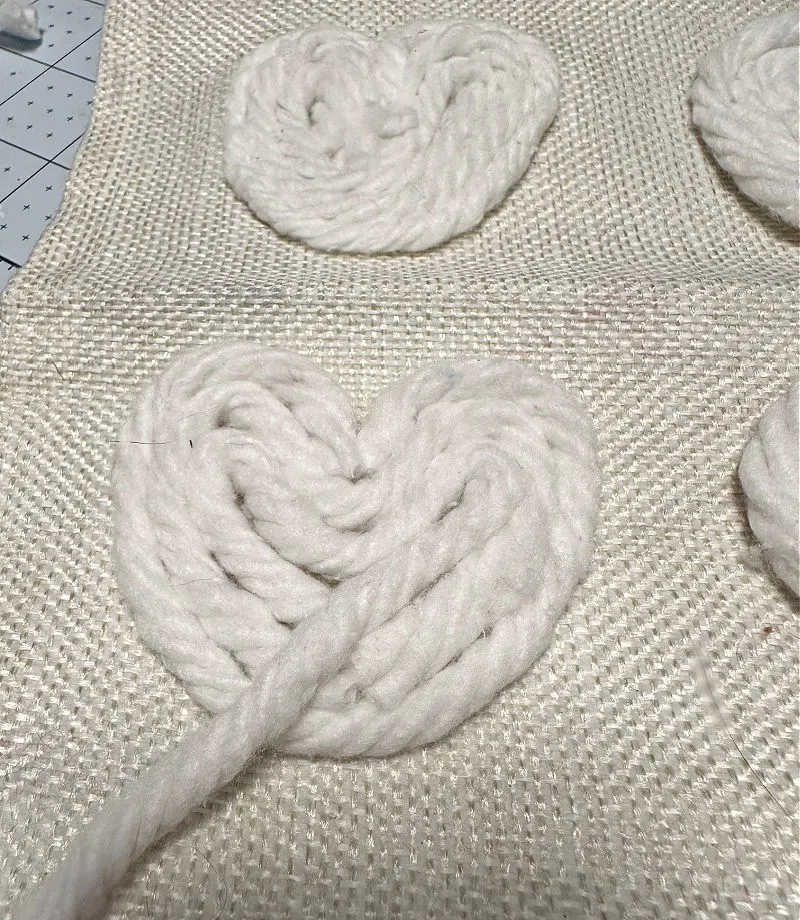 adding yarn to pillow for hearts