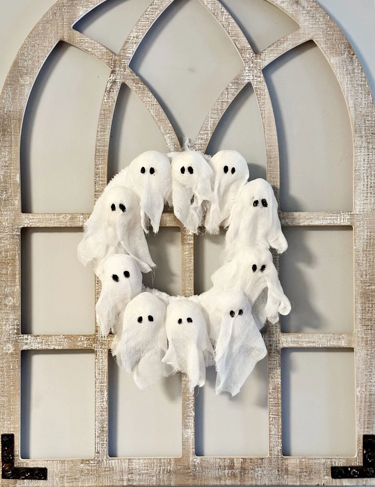 DIY Ghost Wreath Pottery Barn Dupe hanging on arch window frame