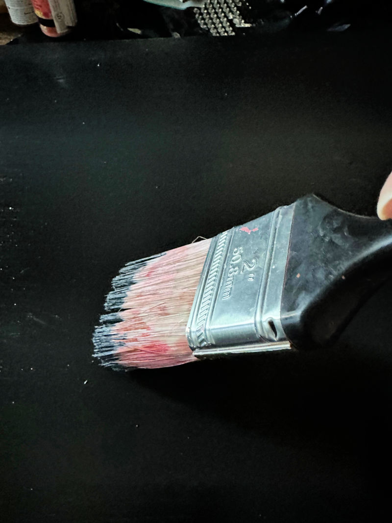 painting canvas with black acrylic paint