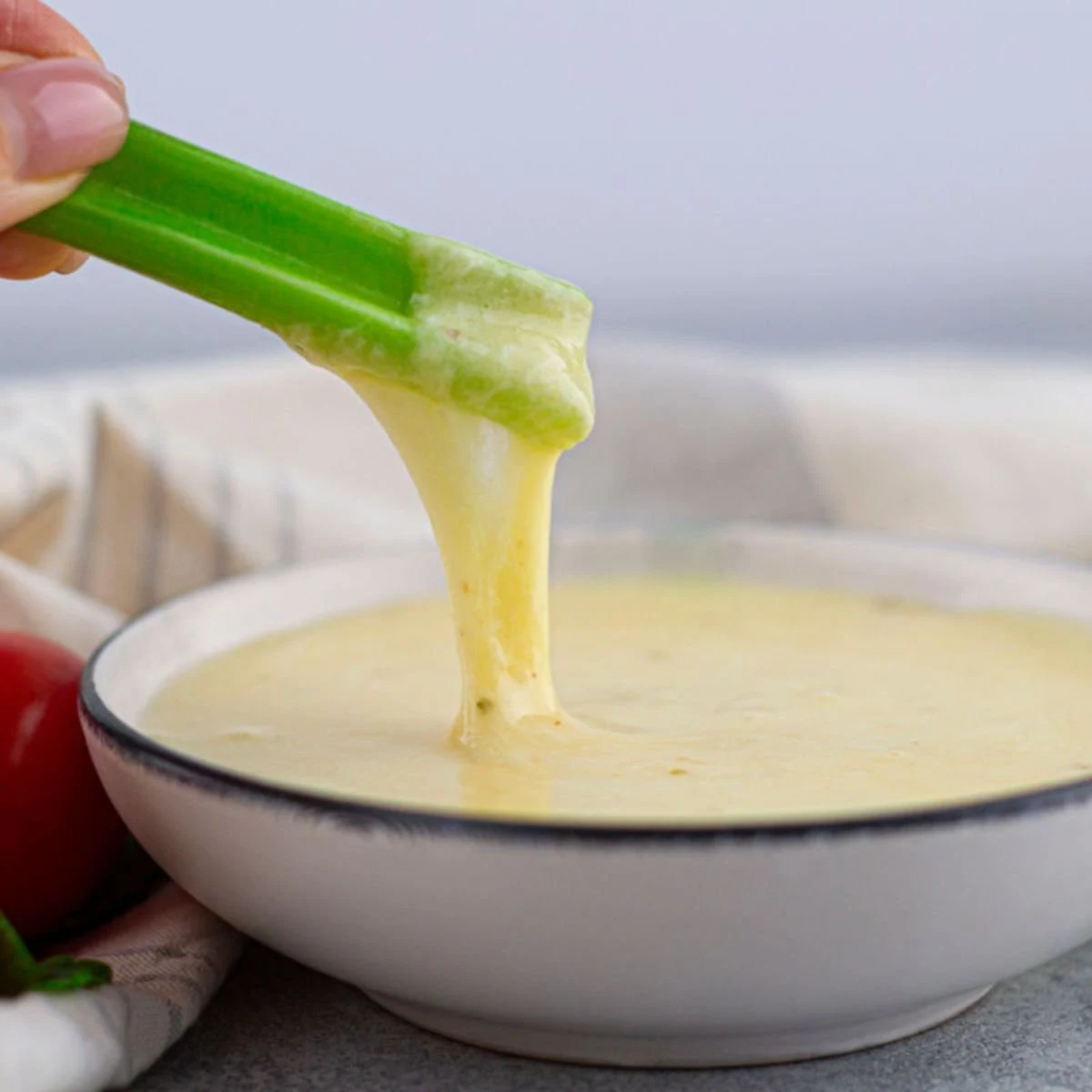 dipping celery into cheese fondue