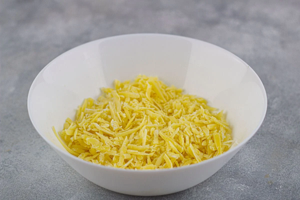 adding cheese to bowl for fondue