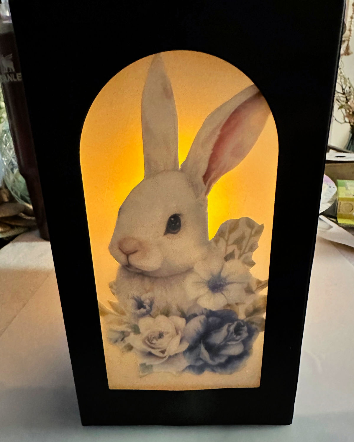 close up of dollar tree lantern with bunny image lit with candle