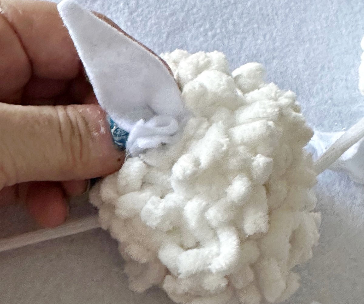 gluing bunny ears on pom pom garland
