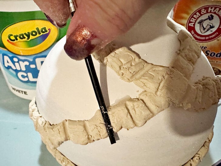 using paint brush handle to indent clay