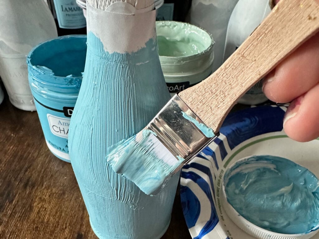 using brush to paint champagne bottle
