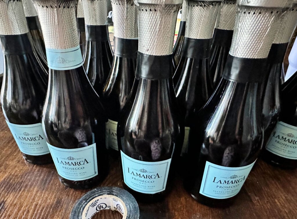 champagne bottles being taped off for spray painting