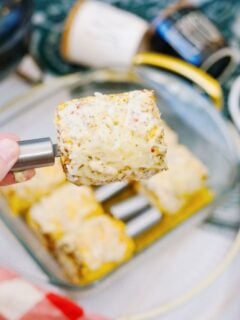 garlic parmesan corn on the cob with hand holding ear of corn