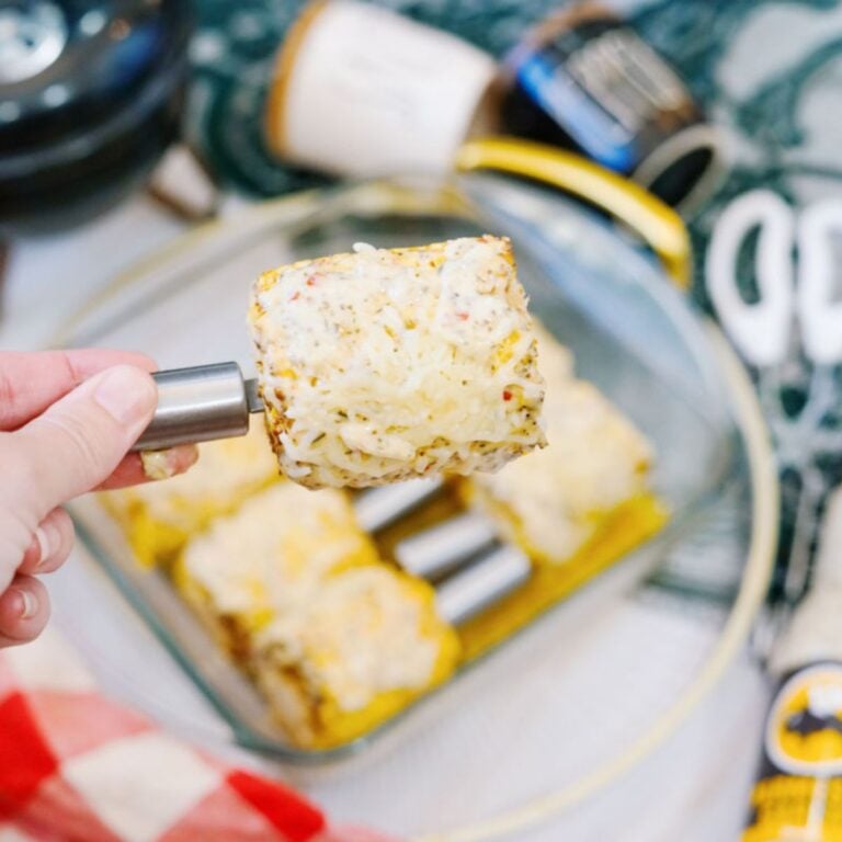 garlic parmesan corn on the cob with hand holding ear of corn