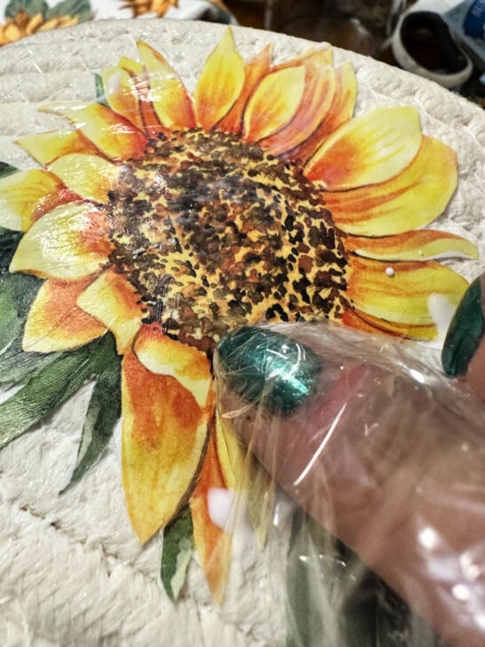 using a plastic bag to smooth out image with mod podge