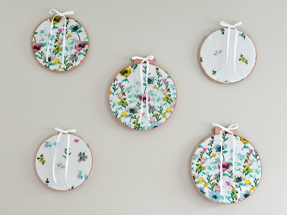 thrift store embroidery hoops on wall with fabric and bows