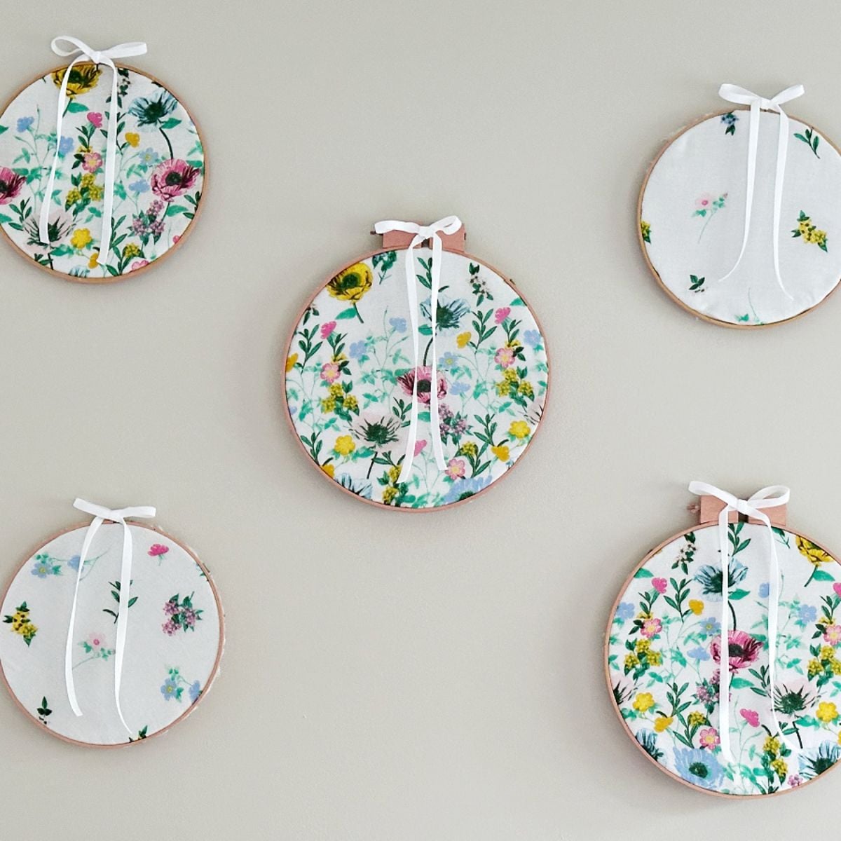 5 fabric embroidery hoops on wall above bed