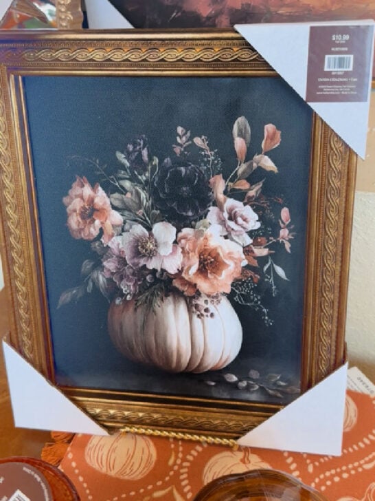 gold framed wall art with white pumpkin and flowers