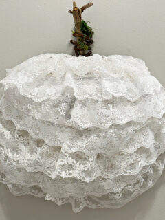 close up of lace pumpkin wreath with wood stem