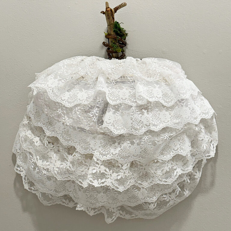 close up of lace pumpkin wreath with wood stem